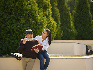 Image showing Portrait of young girl embracing grandfather at park