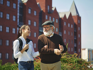 Image showing Portrait of young girl embracing grandfather at park