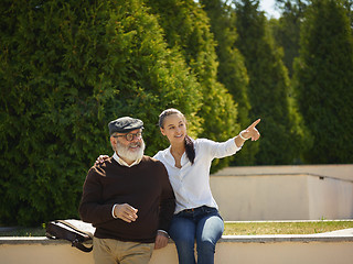 Image showing Portrait of young girl embracing grandfather at park