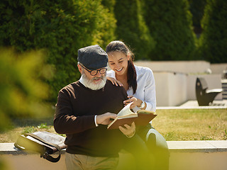 Image showing Portrait of young girl embracing grandfather at park