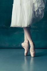 Image showing Close-up ballerinas legs in pointes on the gray wooden floor