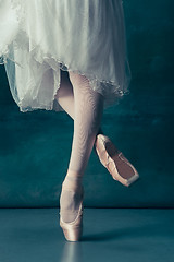 Image showing Close-up ballerinas legs in pointes on the gray wooden floor