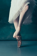 Image showing Close-up ballerinas legs in pointes on the gray wooden floor