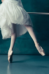 Image showing Close-up ballerinas legs in pointes on the gray wooden floor