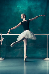 Image showing The classic ballerina posing at ballet barre