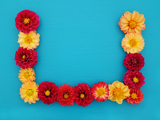 Image showing Three sided border of red and yellow dahlia flowers 