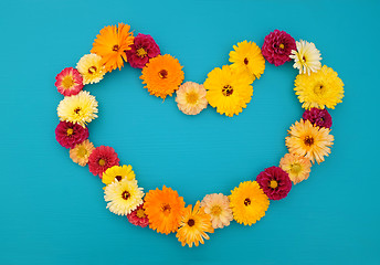 Image showing Hollow heart shape of dahlias and calendulas on teal