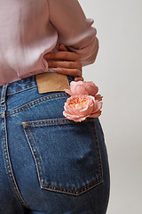 Image showing Perfect woman\'s bottom in a blue jeans and fresh roses living co