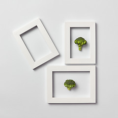 Image showing Creative pattern of frames with natural organic broccoli on a light background.