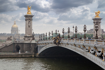 Image showing Pont Alexandre III bridge overlooking the city and the river, cloudy day. France Paris