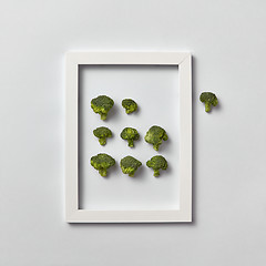 Image showing Organic frame with fresh natural broccoli on a light gray background.