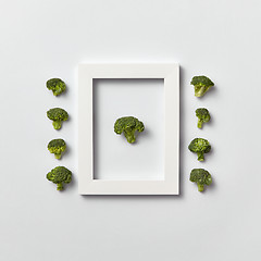 Image showing Organic vegetables pattern with broccoli in a frame and out of it on a light background.