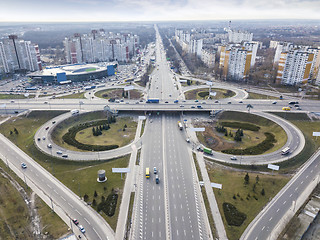 Image showing Aerial view of the drone on the road junction of Odessa square with highway in the form of a quatrefoil with passing cars and a modern city against a cloudy sky. Kiev, Ukraine