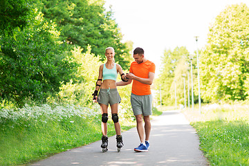 Image showing couple with roller skates riding in summer park