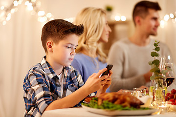 Image showing boy with smartphone at family dinner party