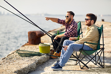 Image showing happy friends with fishing rods on pier