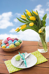 Image showing easter eggs in basket, plates, cutlery and flowers