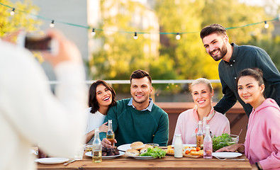 Image showing happy friends photographing at rooftop party