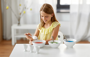 Image showing girl coloring easter eggs by liquid dye at home