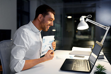 Image showing businessman having video chat at night office