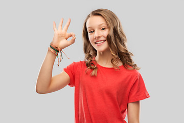 Image showing smiling teenage girl in red t-shirt showing ok