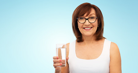 Image showing senior woman in glasses with glass of water