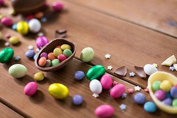 Image showing chocolate eggs and candy drops on wooden table