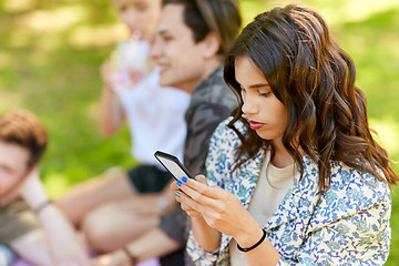 Image showing woman using smartphone at picnic with friends