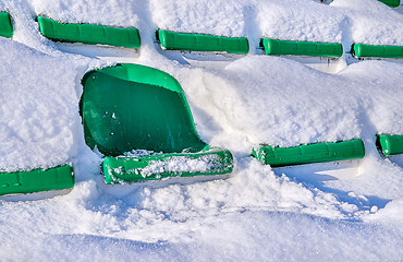 Image showing Green seats of a sports stadium, covered with snow. The concept 