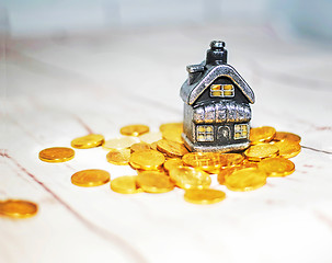 Image showing The house stands on a pile of coins, the concept of cash savings