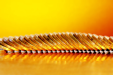 Image showing Coins lying on the Golden surface with a Golden background