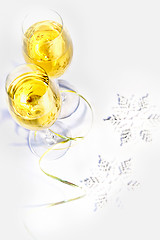 Image showing Two glasses of wine and snowflakes on a white background. Holiday concept.