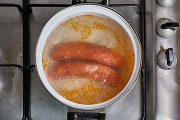 Image showing Boiling sausages on stove