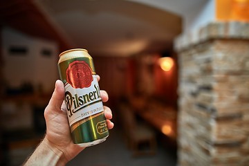 Image showing Holding beer in a house