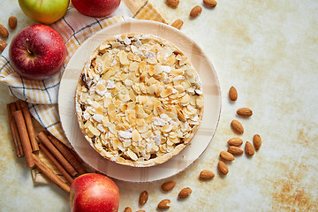 Image showing Freshly baked homemade apple pie with almond flakes cake on yellow