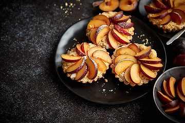Image showing Delicious homemade mini tarts with fresh sliced plum fruit