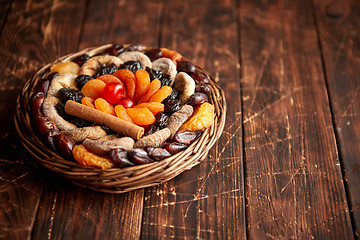 Image showing Mix of dried fruits in a small wicker basket on wooden table