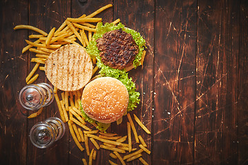 Image showing Two tasty grilled home made burgers with beef, tomato, onion and lettuce