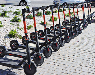 Image showing Electric kick scooter parked on rental station