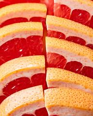 Image showing Fresh slices of ripe grapefruit presented in a row. Healthy Diet Fruit. Flat lay