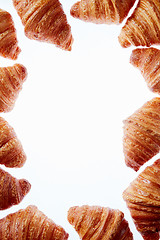 Image showing French croissants frame with copy space on a white background.