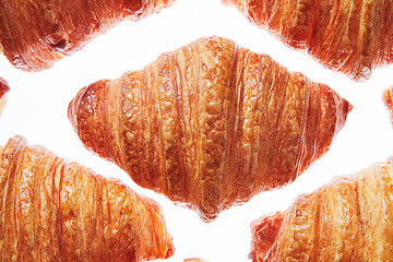 Image showing Close up pattern fresh french croissants on a white background.