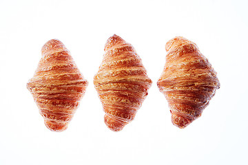 Image showing Set of three homemade french croissants on a white background.