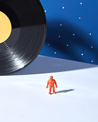 Image showing Astronaut in outer space agaimst of black vinyl record and duotone blue white background