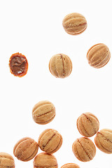 Image showing Falling cookies walnuts with milk cream on a white background.