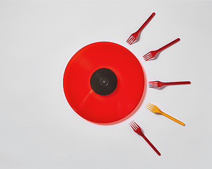 Image showing Red vinyl record with plastic colorfut forks on a gray background.