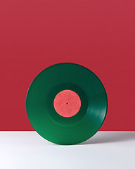 Image showing Vinyl retro record on a double red white background with copy space. Audio technology concept