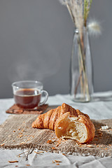 Image showing Morning breakfast still life with fresh croissants and coffee cup on a gray.