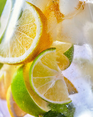 Image showing Macro citrus drink background with lemon and lime slices in a glass.