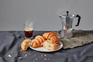Image showing Freshly baked croissants with coffee cup on a dark gray background.